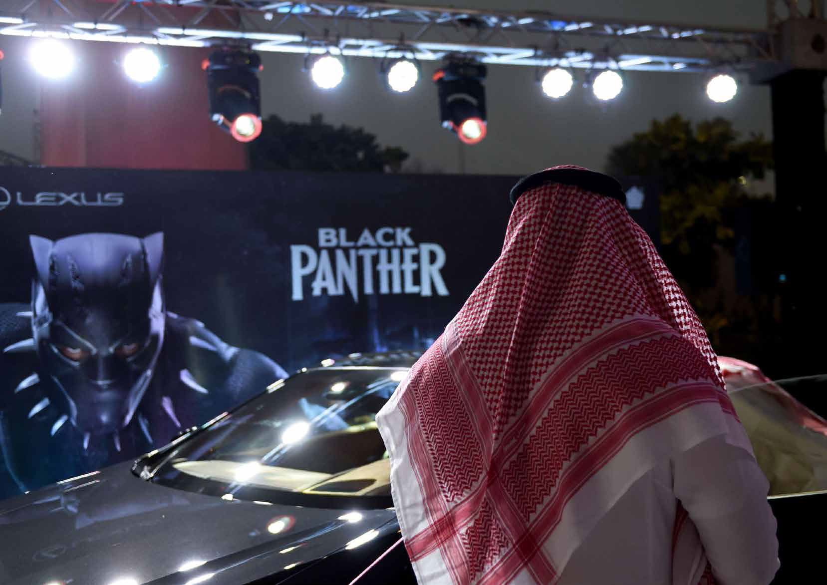 رجل سعودي ينظر إلى سيارة أثناء عرض تجريبي لفيلم "الفهد الأسود" بالرياض في 18 أبريل الماضي